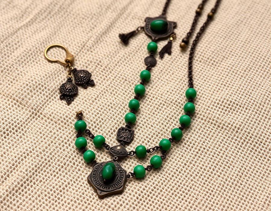 Antique oxidised jewellery with green beads on woven cloth