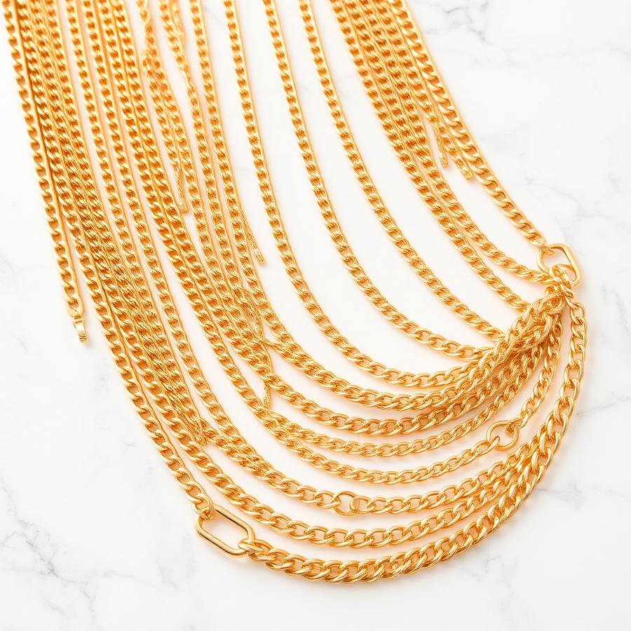 Classic gold chains arranged on white marble